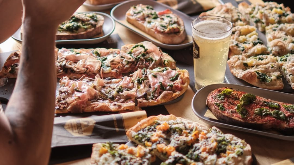 Pinsa à mesa com birra na Il Ponticello