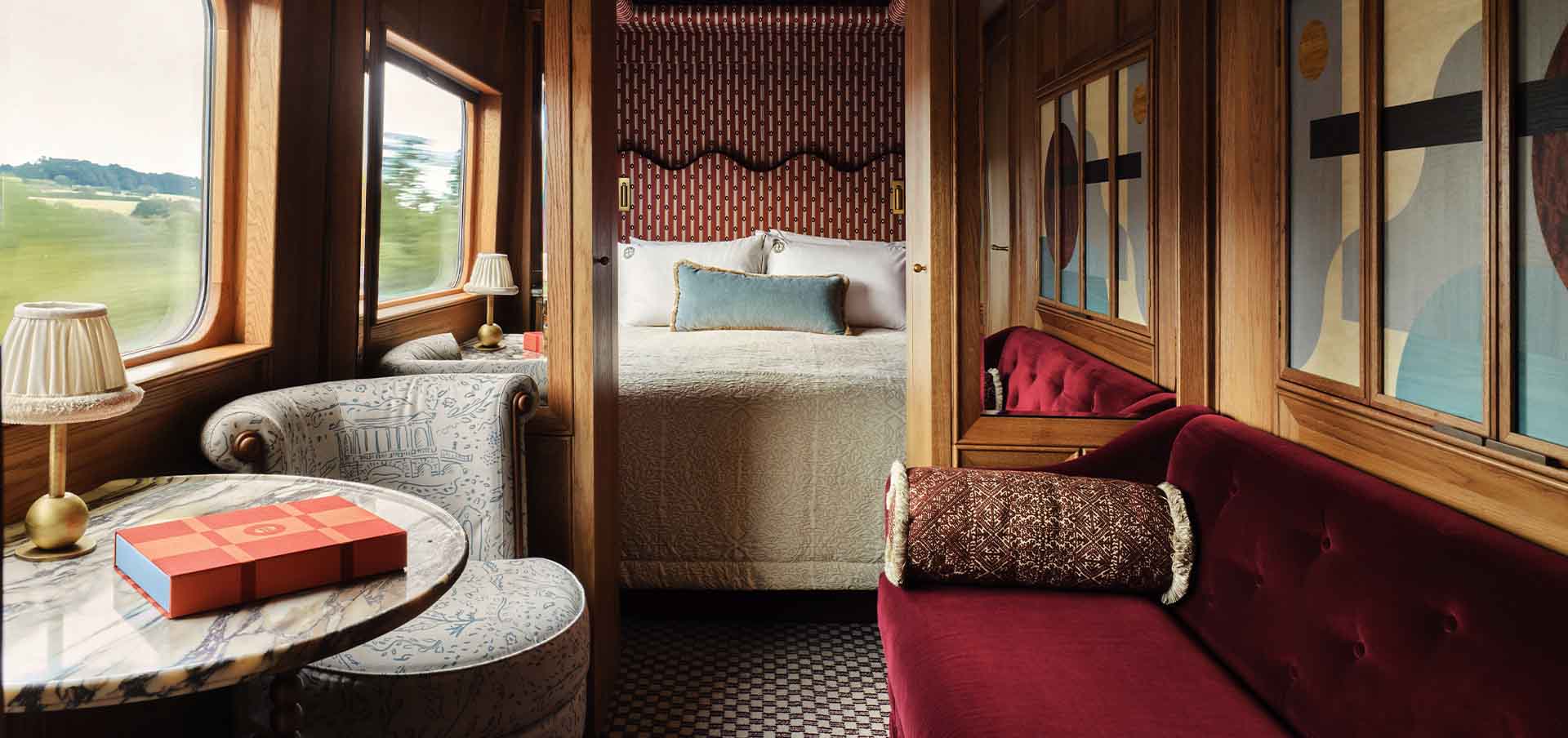 Interior do trem Britannic Explorer da Belmond com suíte decorada e janelas amplas com vista para os campos britânicos.