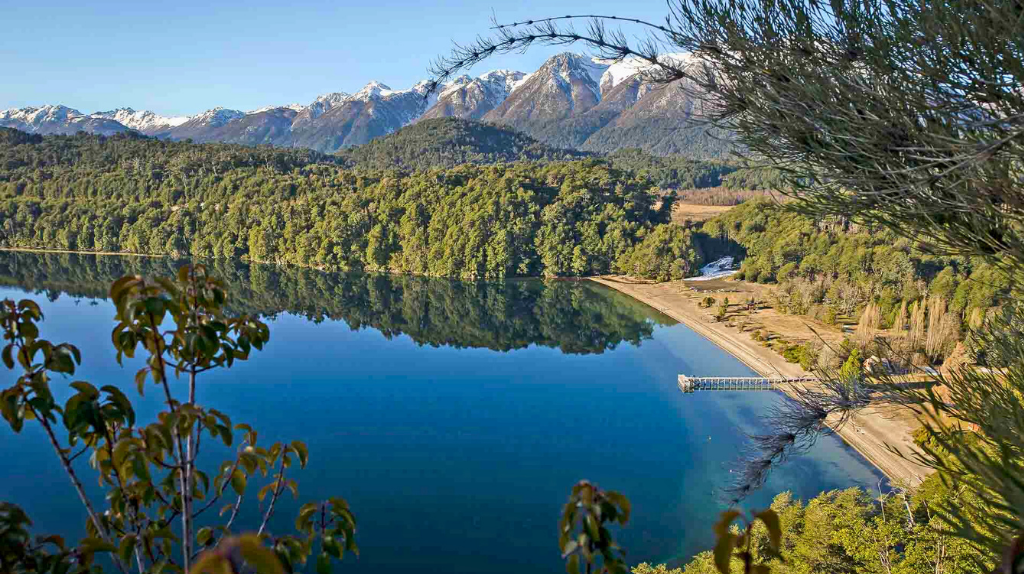 Lago Espejo ao amanhecer: água espelhada refletindo o bosque andino
