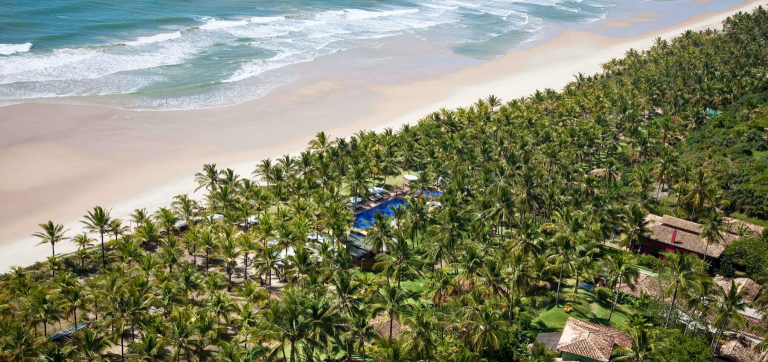 Vista aérea do Txai Resort & Spa em Itacarezinho, sul da Bahia, cercado por coqueiros e mar azul.