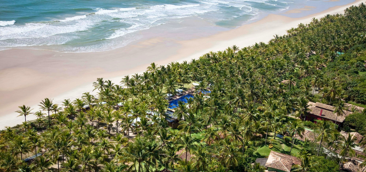 Vista aérea do Txai Resort & Spa em Itacarezinho, sul da Bahia, cercado por coqueiros e mar azul.