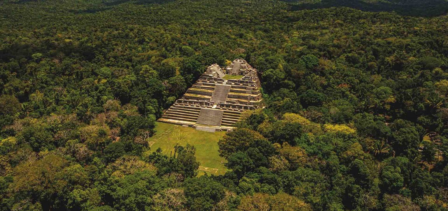Pirâmide maia de Caracol cercada pela floresta tropical em Belize, parada essencial em roteiro de viagem arqueológico