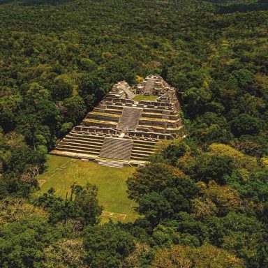 Pirâmide maia de Caracol cercada pela floresta tropical em Belize, parada essencial em roteiro de viagem arqueológico