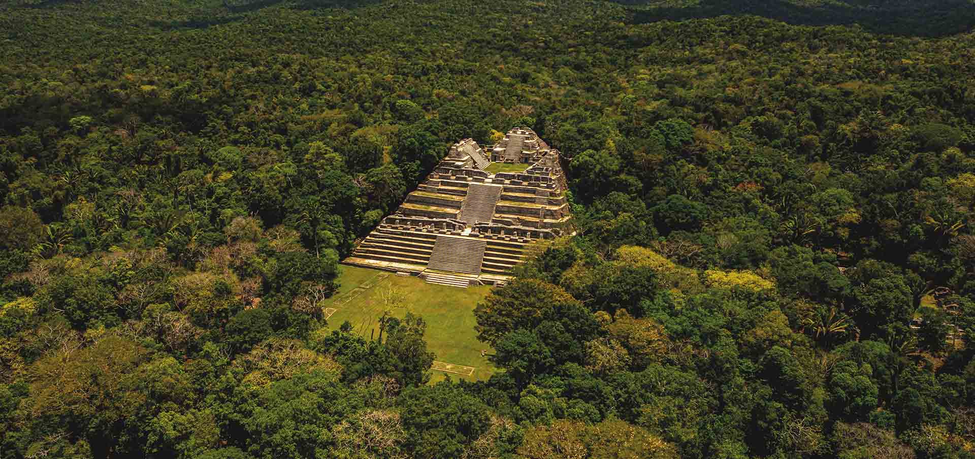 Pirâmide maia de Caracol cercada pela floresta tropical em Belize, parada essencial em roteiro de viagem arqueológico
