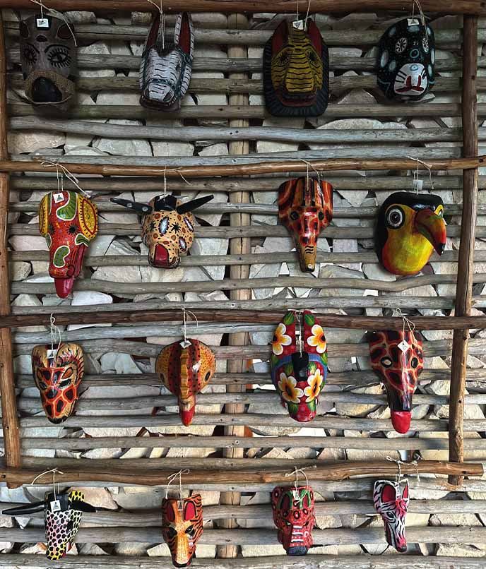 Máscaras coloridas de animais maias na parede do hotel La Lancha, Guatemala, inspiração de decoração típica para onde ficar na Rota Maia