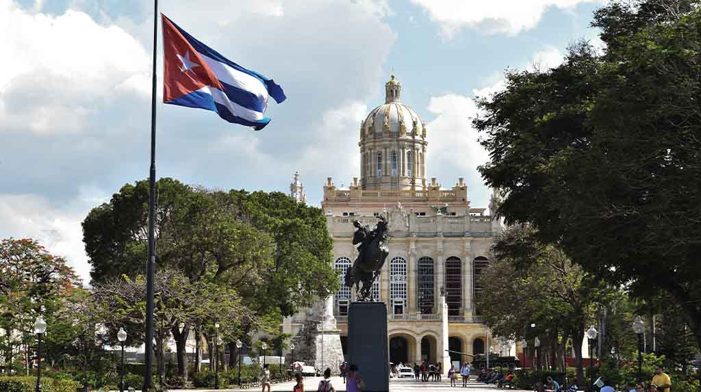 Bandeira de Cuba e cúpula do Museu da Revolução vistas da praça em Havana, parada central em qualquer roteiro sobre história de Cuba