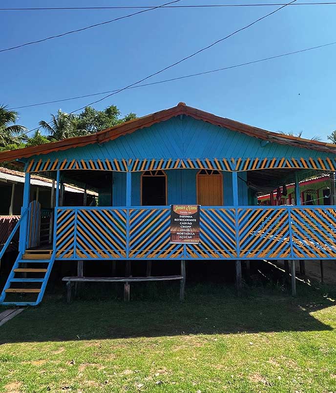 Fachada azul e amarela de casa tradicional na comunidade da Praia do Céu, em Soure, destacando arquitetura ribeirinha marajoara