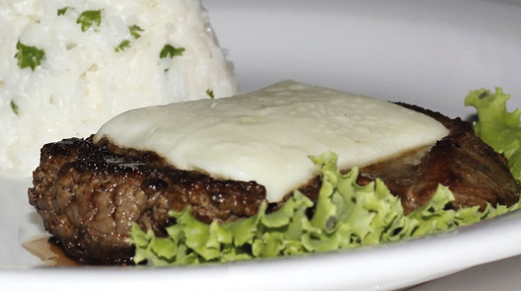 Filé marajoara servido com queijo de búfala derretido e arroz, prato típico da culinária de Soure, Ilha de Marajó