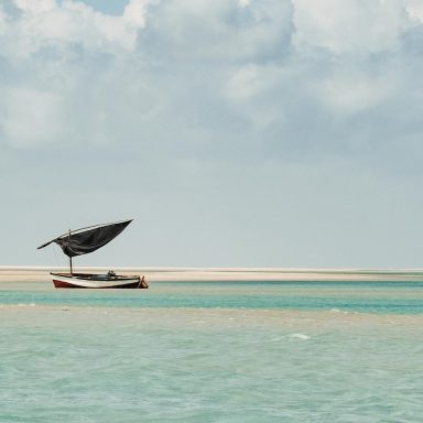 Barco dhow tradicional nas águas turquesa da Ilha de Benguerra, uma expressão da arte viva e da natureza de Moçambique