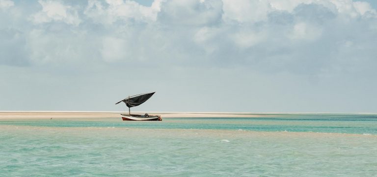 Barco dhow tradicional nas águas turquesa da Ilha de Benguerra, uma expressão da arte viva e da natureza de Moçambique