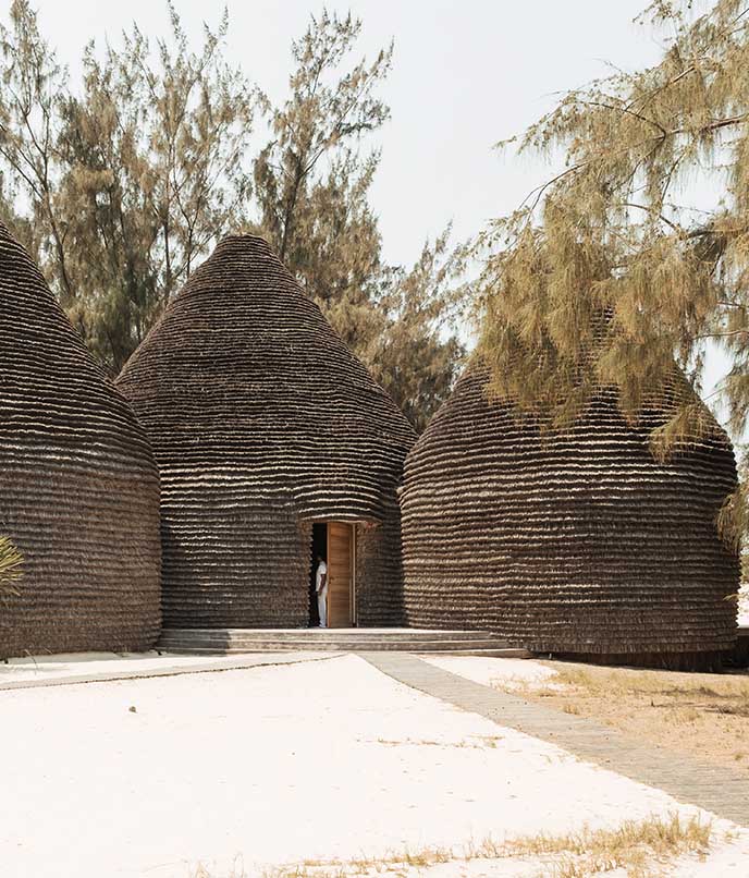 Arquitetura sustentável do Kisawa Sanctuary com estruturas abobadadas revestidas de palha, inspiradas nas habitações nativas de Moçambique.