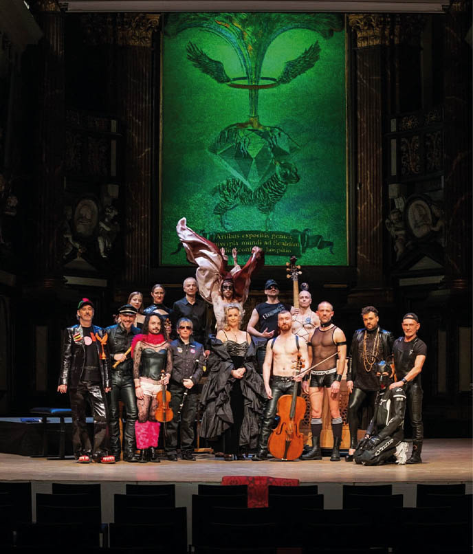 Elenco queer em figurinos ousados no palco de teatro em Antuérpia, Bélgica, mostrando cena cultural LGBTQIA+ em viagem pela cidade