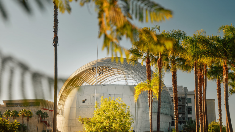 Cúpula esférica do Academy Museum of Motion Pictures entre palmeiras, em Los Angeles, exemplo de arquitetura contemporânea (Renzo Piano) citado no tour Building Dreams in Beverly Hills