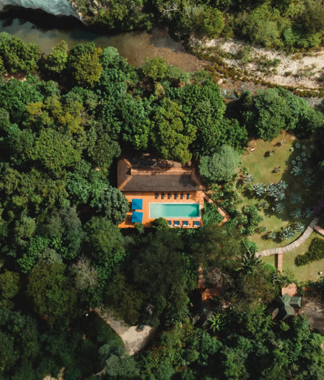Vista aérea da Fazenda Shanti na Chapada dos Veadeiros, com piscina cercada pela mata e o rio São Miguel ao fundo A piscina da Fazenda Shanti