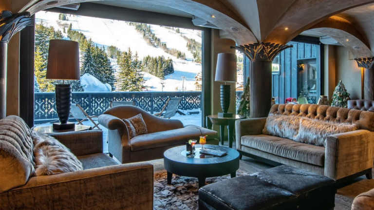 Lounge do Hôtel Le Lana (Courchevel 1850) com janelão panorâmico para as pistas de esqui e o bosque nevado nos Alpes. Lounge do Hôtel Le Lana (Courchevel 1850)