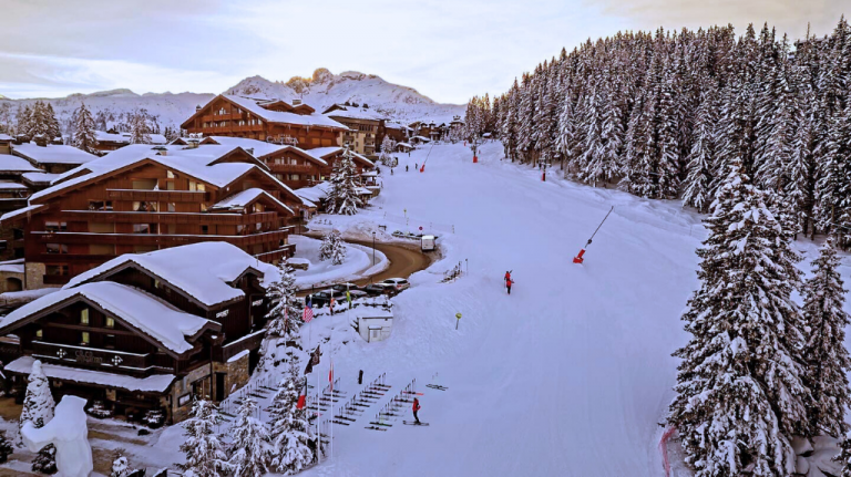 Pista de esqui ao lado do Hôtel Le Lana, em Courchevel 1850, com chalés e floresta de pinheiros nevados, cenário ski-in/ski-out. Pista de esqui ao lado do Hôtel Le Lana, em Courchevel 1850