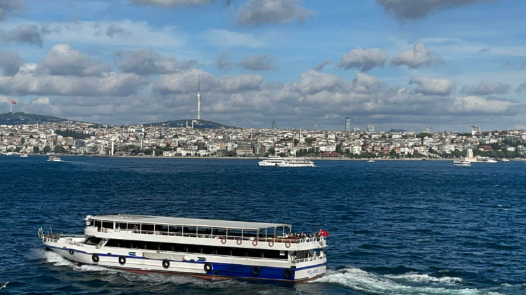 Travessia de barca rumo ao lado asiático de Istambul, com o Bósforo em primeiro plano e a cidade ao fundo Barca atravessando o Bósforo, com o skyline de Istambul ao fundo