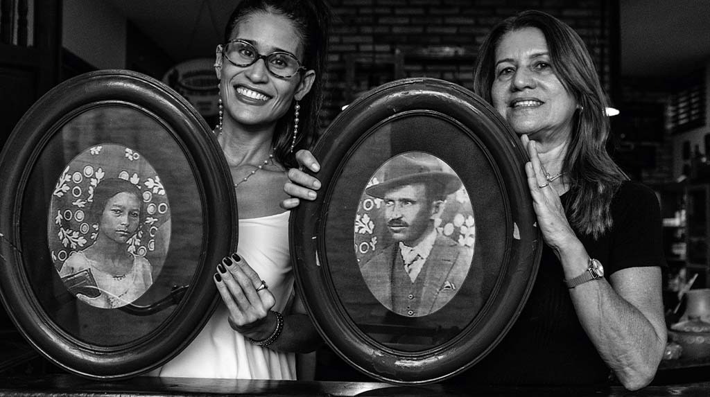 
Retrato de produtores ao lado de barris em alambique mineiro, em matéria sobre patrimônio cultural, tradição rural e cachaça de alambique em Minas Gerais.