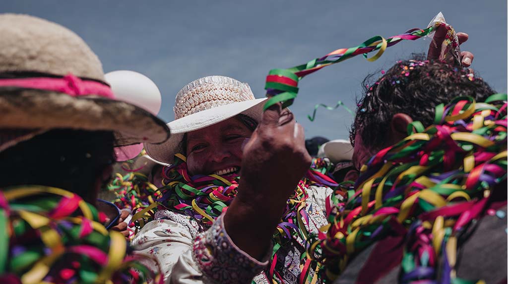 Celebração da Pachamama com trajes tradicionais, fitas coloridas e rituais andinos