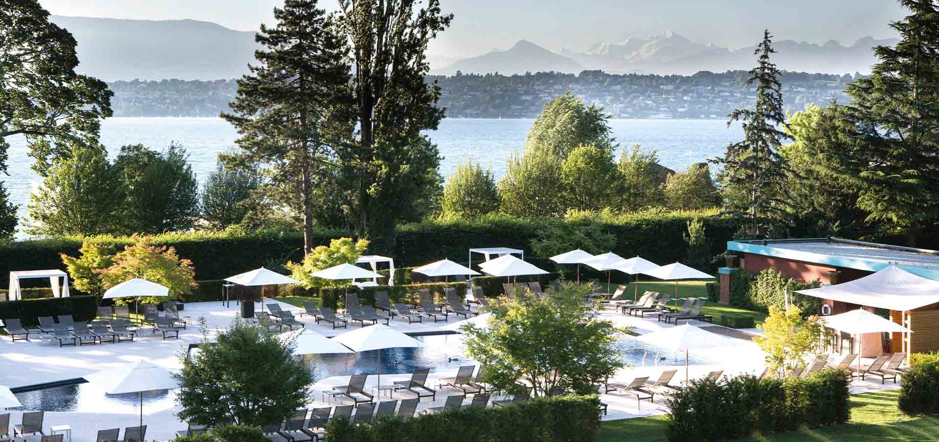 Vista dos jardins do La Réserve Genève, em Bellevue, perto de Genebra, no oeste da Suíça, com o Lago Léman ao fundo em matéria sobre wellness e Nescens Spa.