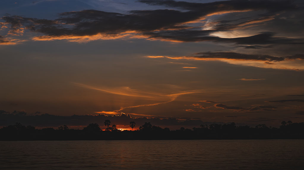 Pôr do sol na África durante viagem de safári entre rios, savanas e áreas de conservação.