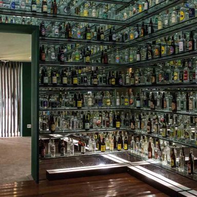 Sala com garrafas e rótulos de cachaça de alambique em Minas Gerais, no Sudeste do Brasil, em roteiro cultural sobre tradição, patrimônio e história mineira.