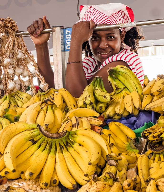 Vendedora em mercado de Cabo Verde, em roteiro cultural pelo arquipélago que conecta música, gastronomia, vida cotidiana e identidade local