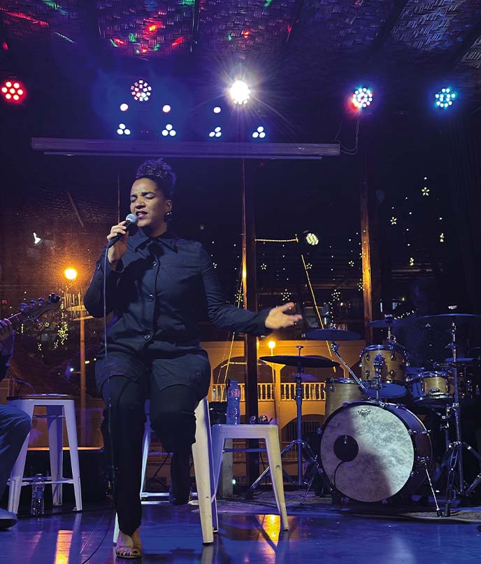 Cantor se apresenta em palco durante show de música cabo-verdiana, em artigo sobre morna, coladeira, funaná e roteiro musical em Cabo Verde