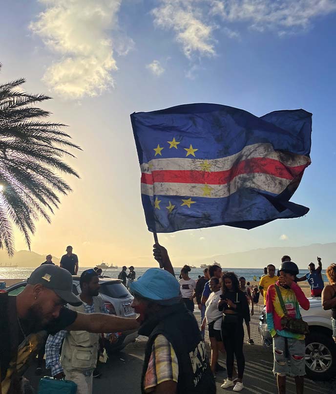Bandeira de Cabo Verde em evento público, em artigo sobre roteiro musical pelo arquipélago, identidade nacional, morna e cultura crioula.