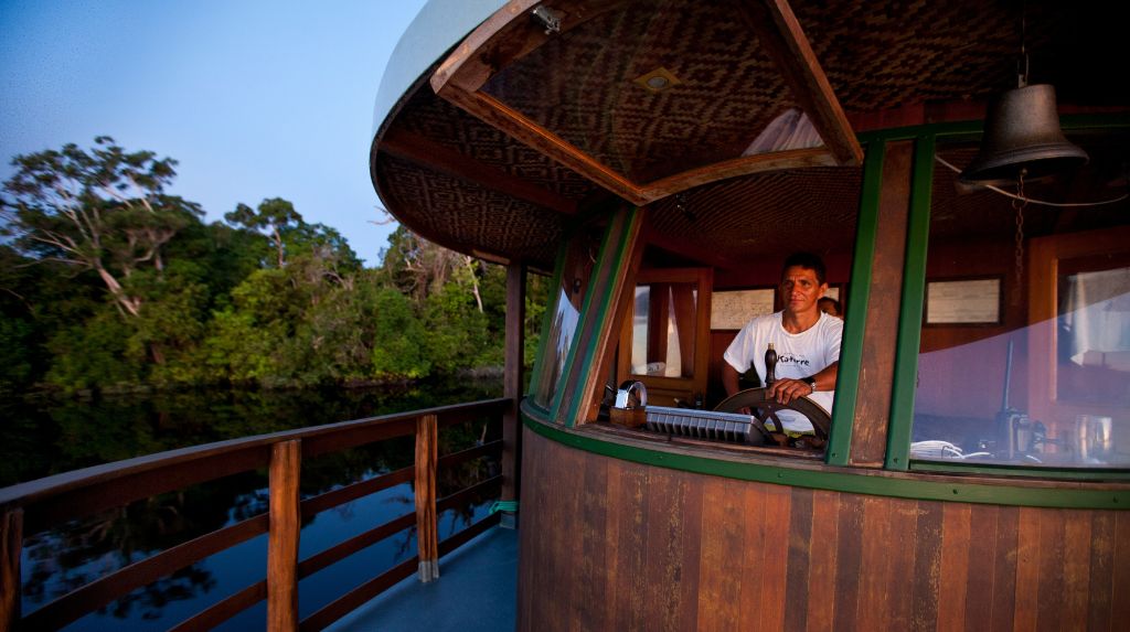 Construído em madeira maciça, o Jacaré-açu tem oito cabines-suíte climatizadas, salão de refeições, sala de convivência e cinema, além de solário com cobertura retrátil e rede